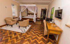 a living room with a bed and a desk and a desk at The Blixen Resort & Spa in Nairobi