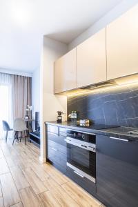 uma cozinha com armários brancos e um balcão azul em Nowe Ptasie, Osiedle Ptasie, apartment 30, NEW - LUX - PARKING em Katowice