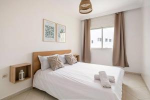 um quarto com uma cama branca e uma janela em Rabat Centro Apartments em Rabat