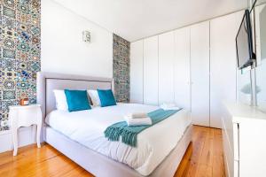 - une chambre avec un lit blanc et des oreillers bleus dans l'établissement The Mosaics Studio @ Porto Centre w/ Balcony, à Porto