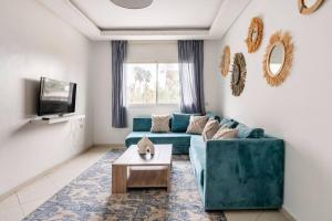 salon z niebieską kanapą i stołem w obiekcie Rabat Centro Apartments w mieście Rabat