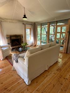 Ole Samara guest suites في نانيوكي: غرفة معيشة مع أريكة كبيرة ومدفأة