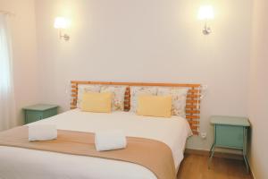 una camera da letto con un letto con cuscini gialli e due tavoli di I Love Dão Casas Da Fraga a São Gemil Altre 28 foto