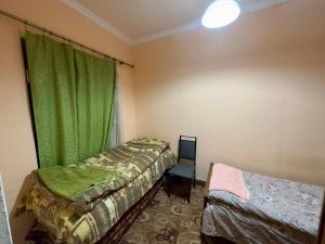 a room with two beds and a green curtain at NunSon Guest House in Yerevan