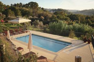 a swimming pool with a wooden deck and a fence at I Love Dão Casas Da Fraga in São Gemil