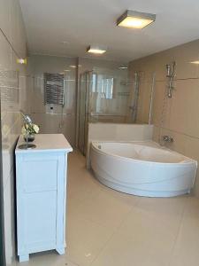 duża łazienka z dużą wanną i umywalką w obiekcie Penthouse Silver Mountain, Duplex 3 camere - 250 mp luxury garden - Poiana Brasov w Braszowie