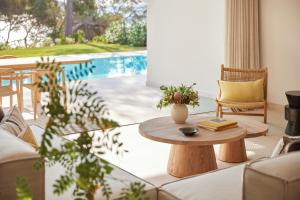 a living room with a table and a pool at Ikos Porto Petro in Portopetro