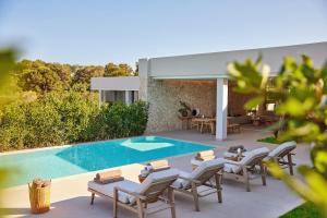 a patio with chairs and a swimming pool at Ikos Porto Petro in Portopetro