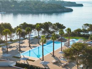 an aerial view of a resort with palm trees and water at Ikos Porto Petro in Portopetro