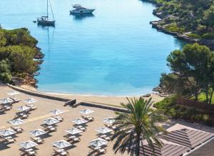 an aerial view of a beach with chairs and boats in the water at Ikos Porto Petro in Portopetro