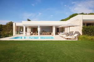 a villa with a swimming pool in a yard at Ikos Porto Petro in Portopetro