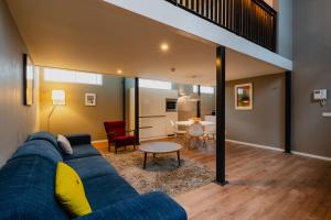 a living room with a blue couch and a table at Apartments De Hallen in Amsterdam