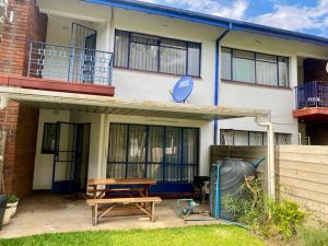 a house with a picnic table in front of it at Lovely 2 bed apartment with garden - 2047 in Harare