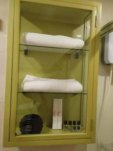 a cabinet with three towels and a mirror in a bathroom at Relaxing Studio at Morgan Suites walking distance Venice Piazza T219P in Manila