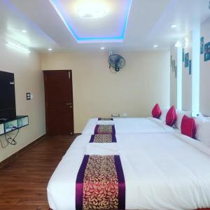 a bedroom with a large white bed with a blue ceiling at Paradise Breeze Inn in Kottakupam