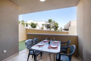 a table and chairs on a balcony with a table and a window at Residencial en el Médano in El Médano