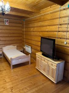a room with a bed and a flat screen tv at Chata z góralską duszą in Jabłonka