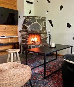 a living room with a table and a fireplace at Kodikas loma-asunto Tahkon ytimestä in Tahkovuori