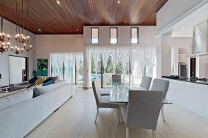 a dining room and living room with a glass table at Mandala by Villacarte in Bang Tao Beach