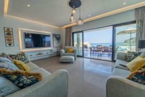 uma sala de estar com dois sofás e uma grande janela em Villa Halcyon em Agios Stefanos