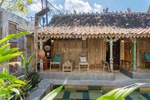 a guest house with a pool in front of it at Kayu Beach Villa by TwoSpaces, Nusa Dua Beach in Nusa Dua