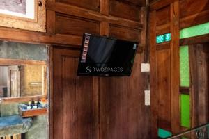 a television hanging on a wall in a room at Kayu Beach Villa by TwoSpaces, Nusa Dua Beach in Nusa Dua
