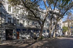 a large building with a tree in front of it at Metro Hotel Apartments in Odesa