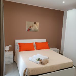 ein Schlafzimmer mit einem Bett mit orangefarbenen Kissen in der Unterkunft Casa Bonelli 37 in Barletta