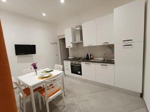 a kitchen with white cabinets and a table and a sink at Casa Bonelli 37 in Barletta
