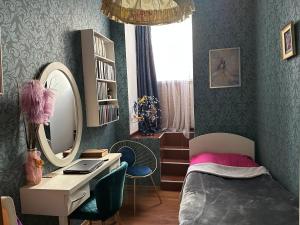 a bedroom with a bed and a desk and a mirror at Guest house tm in Tbilisi City