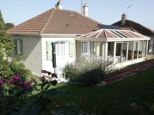 uma casa branca com um jardim de Inverno com um telhado em LES GRADINES em Bar-sur-Aube