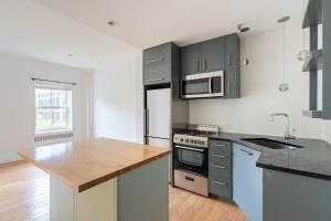 een keuken met grijze kasten en een houten aanrecht bij Apartment 1287: Chelsea in New York