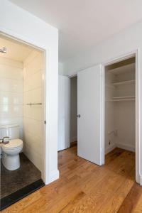 a white bathroom with a toilet and a closet at Apartment 1287: Chelsea in New York