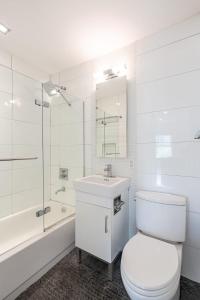 een witte badkamer met een toilet en een wastafel bij Apartment 1287: Chelsea in New York