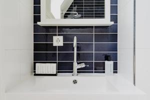 cocina con fregadero y azulejos negros en Apartments De Hallen, en Ámsterdam 61 fotos más