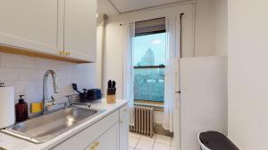 a kitchen with a sink and a large window at Apartment 682: Columbus Circle in New York