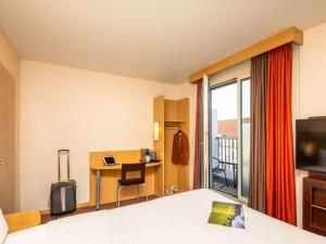 um quarto de hotel com uma cama e uma secretária em ibis Basel Bahnhof em Basileia