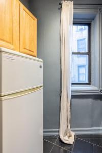 ニューヨークにあるApartment 242: Upper West Sideのキッチン(冷蔵庫付)、窓が備わります。