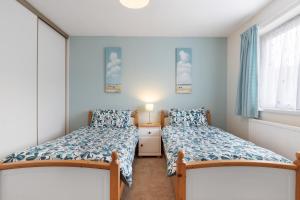 une chambre avec deux lits et une fenêtre dans l'établissement Oaklands - Lovely Cottage Walk to Beach, à Saundersfoot