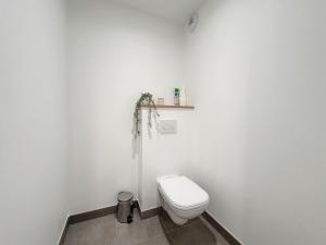 a white bathroom with a toilet and a shelf on the wall at SAGLIO - Neuf - Parking - Tram - Spa in Strasbourg
