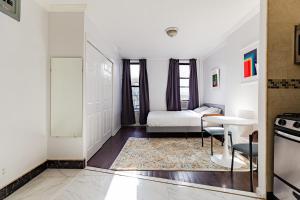 a small room with a bed and a table and a kitchen at Apartment 1720: East Village in New York