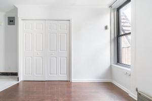 una stanza vuota con una porta bianca e una finestra di Apartment 1720: East Village a New York