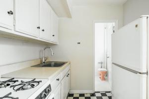 cocina blanca con fregadero y nevera en Apartment 1333: East Village, en Nueva York