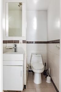 y baño con aseo, lavabo y espejo. en Apartment 1720: East Village en Nueva York