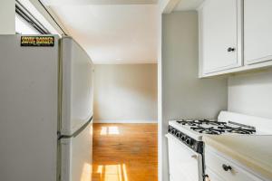 cocina blanca con fogones y nevera en Apartment 1333: East Village, en Nueva York
