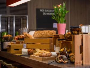 un tavolo ricoperto da molti tipi diversi di pane di ibis Styles Romans-Valence Gare TGV ad Alixan