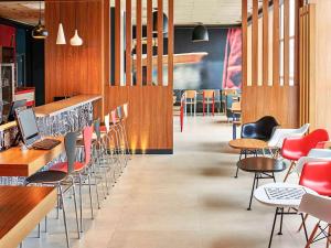 a restaurant with chairs and tables and a bar at Ibis Guaratingueta Aparecida - Circuito da Fé in Guaratinguetá