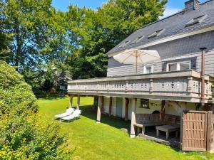 a house with a deck with chairs and an umbrella at Tante Hanna in Winterberg