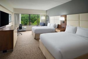um quarto de hotel com duas camas e uma televisão de ecrã plano em Doubletree by Hilton Hotel Williamsburg em Williamsburg