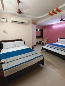a bedroom with two beds in a room at Hotel DKR Residency in Tirupati
